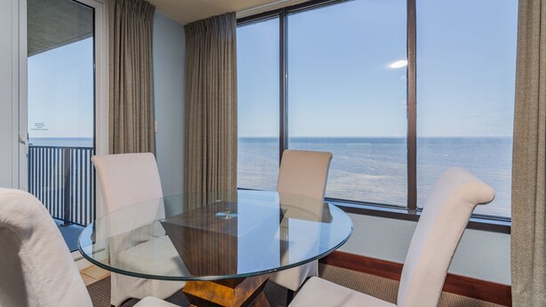 A glass-top table with four chairs in a room with large windows overlooking the sea. - Sandestin Golf and Beach Resort (Miramar Beach)