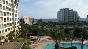 A resort with a pool area, palm trees, and a view of the ocean. - Sandestin Golf and Beach Resort (Miramar Beach)