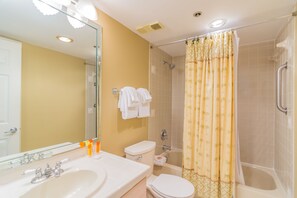 Un baño con lavamanos, inodoro y ducha.