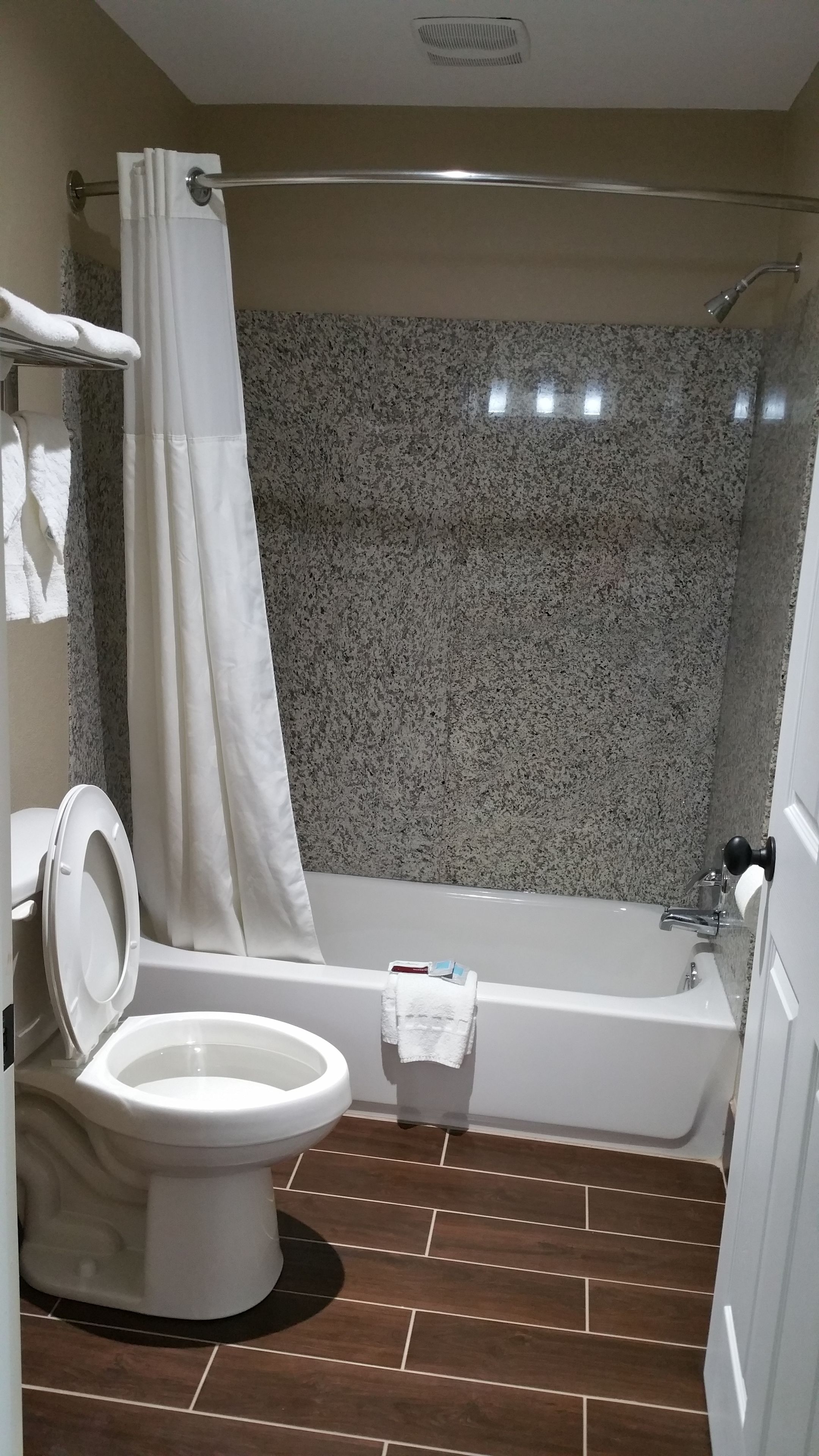 Un baño con inodoro, bañera y cortina de ducha.