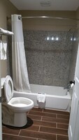 Un baño con inodoro, bañera y cortina de ducha.