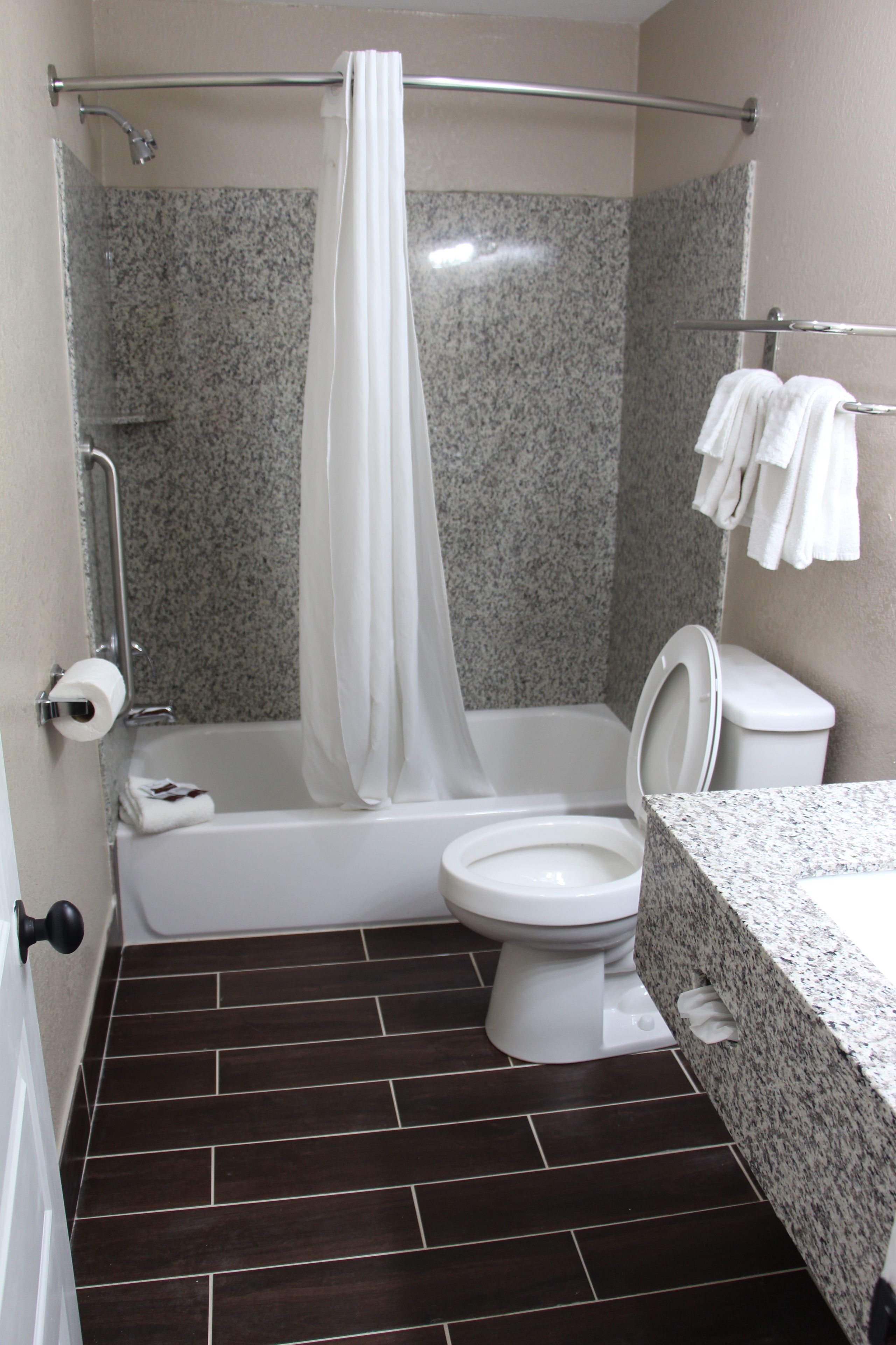 A bathroom with a shower, toilet, and sink.