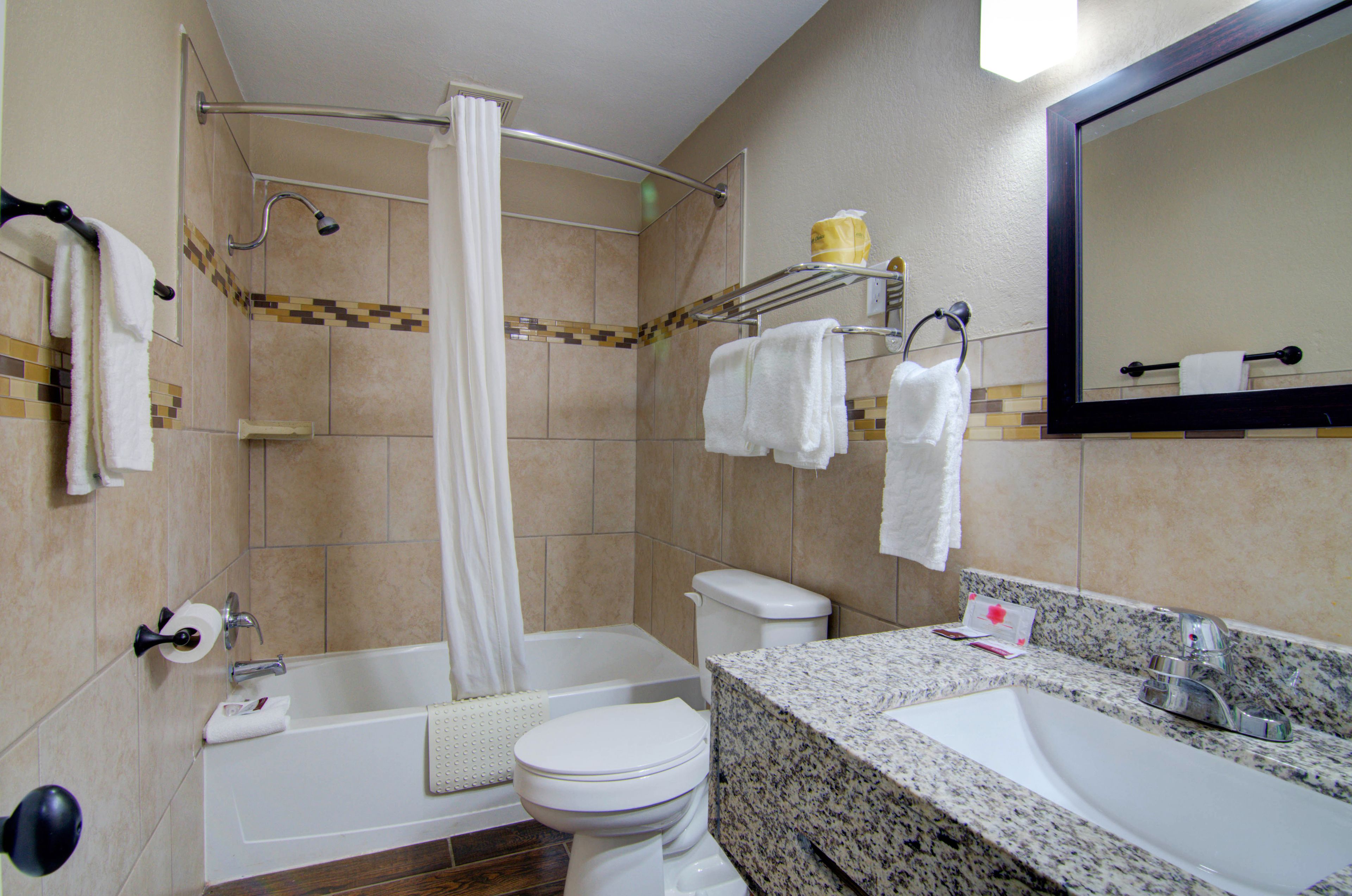 A bathroom with a bathtub, toilet, and sink.