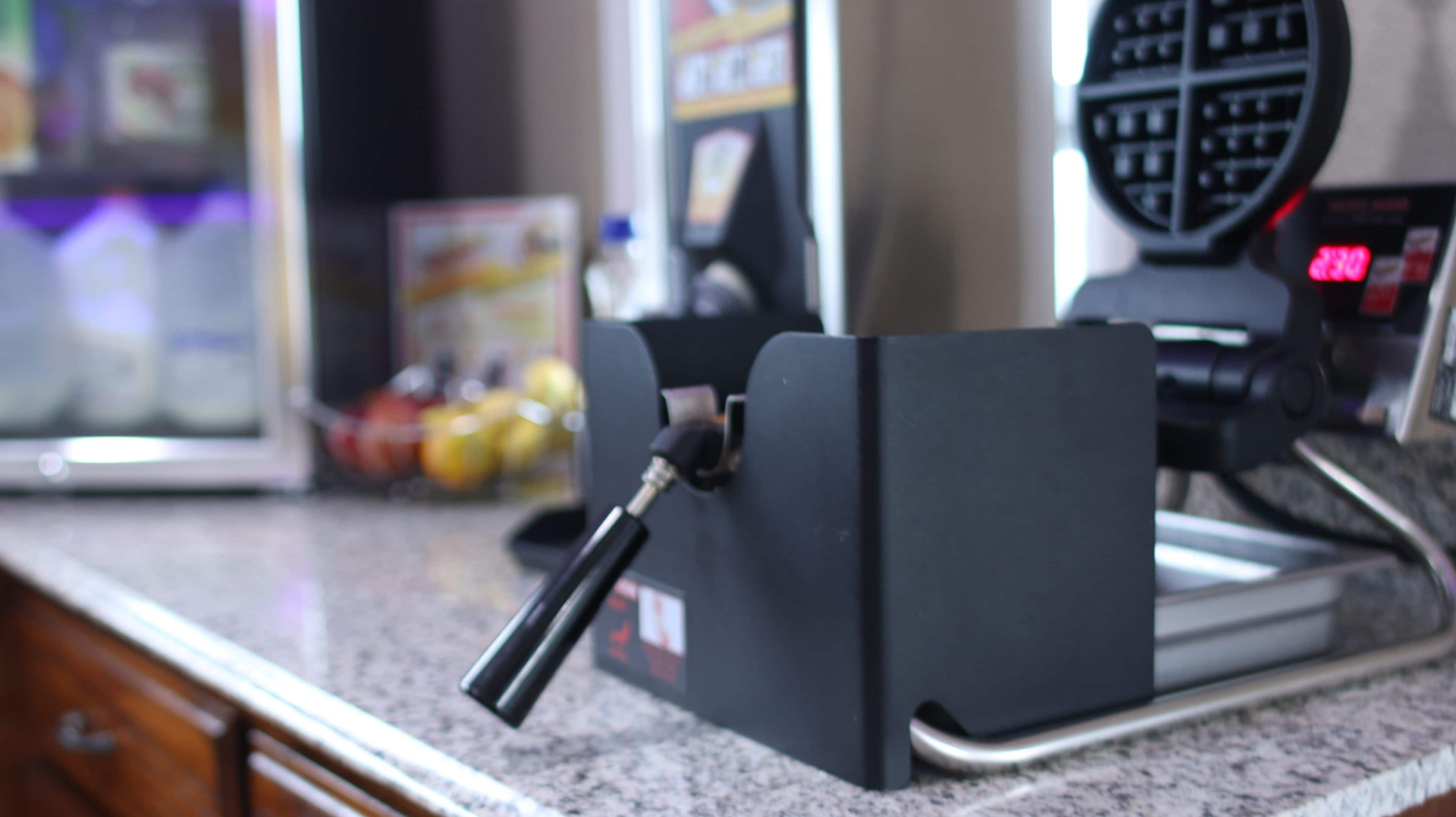 A coffee machine with a drip tray on a granite countertop.