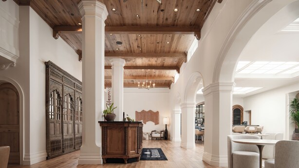 A spacious interior with high ceilings, wooden beams, and a central column.