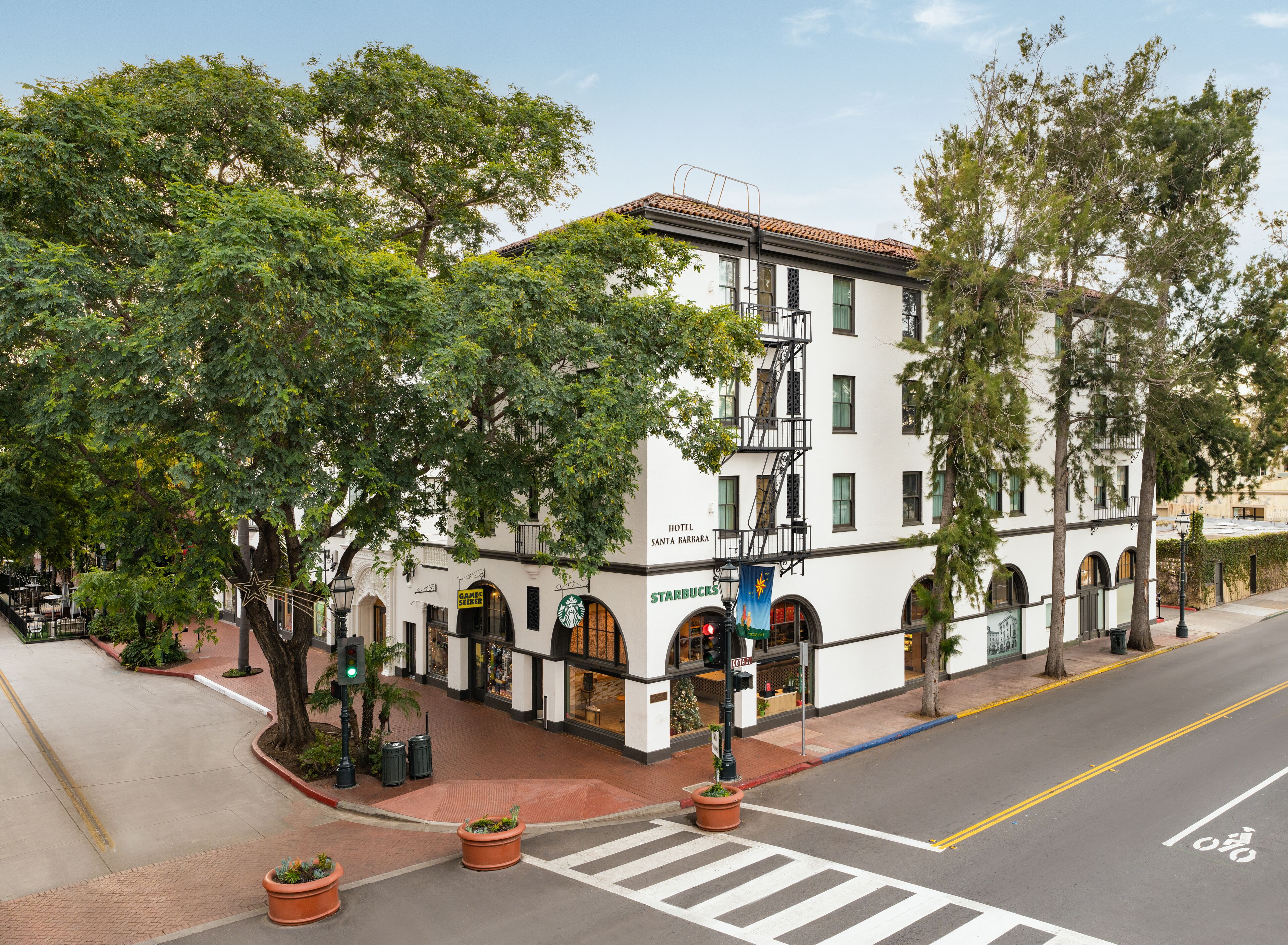 A white building with arched windows and a sign for 'Hotel Santa Barbara'.