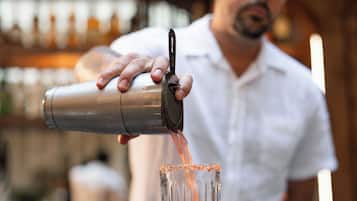 A bartender pouring a drink into a glass.