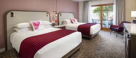 A hotel room with two beds, a desk, and a chair.