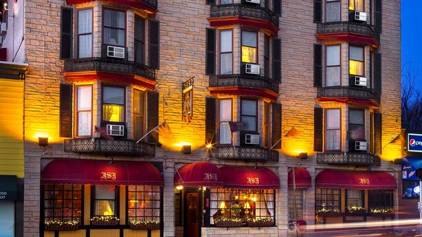 A multi-story building with a stone facade, multiple windows, and awnings. - Inn at St John Portland In-Town (Portland)