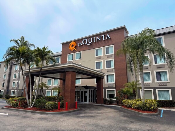 Ein Hotel namens La Quinta mit moderner Fassade, zahlreichen Fenstern und einem überdachten Eingangsbereich.