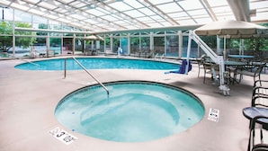An indoor swimming pool with a glass ceiling, a hot tub, and outdoor seating. - La Quinta Inn & Suites by Wyndham Cincinnati NE - Mason (Mason)
