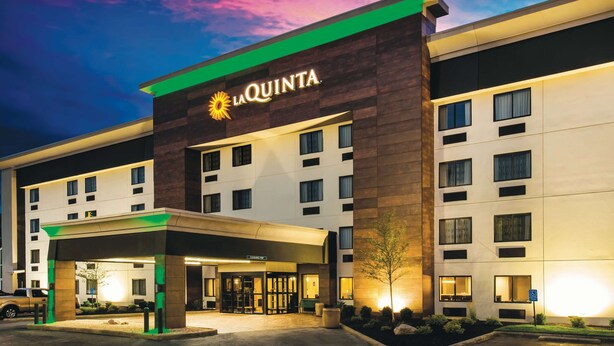 A La Quinta hotel with a modern facade, multiple windows, and a well-lit entrance. - La Quinta Inn & Suites by Wyndham Cincinnati NE - Mason (Mason)
