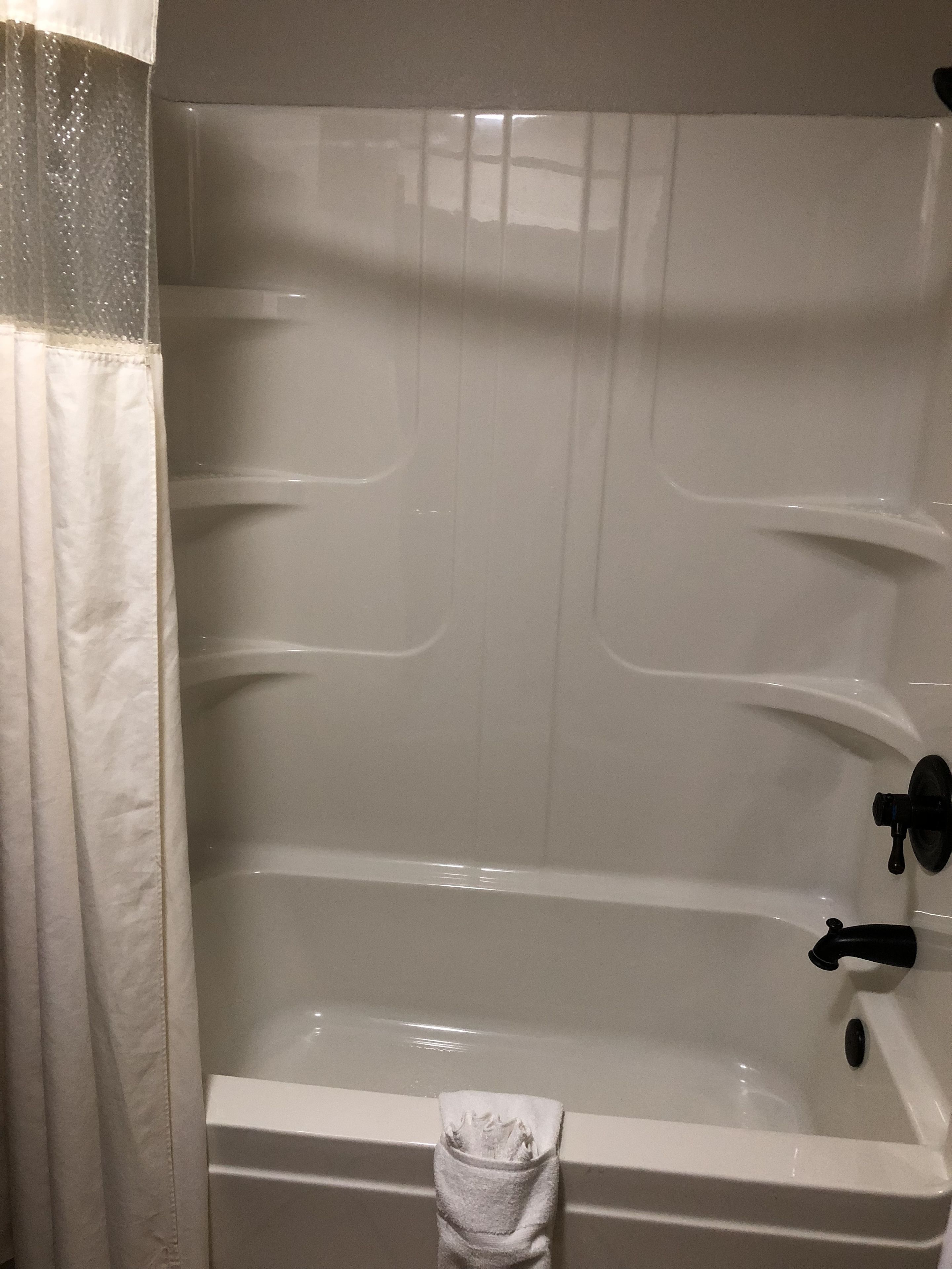 Une salle de bain avec une baignoire, un porte-serviettes et un rideau.