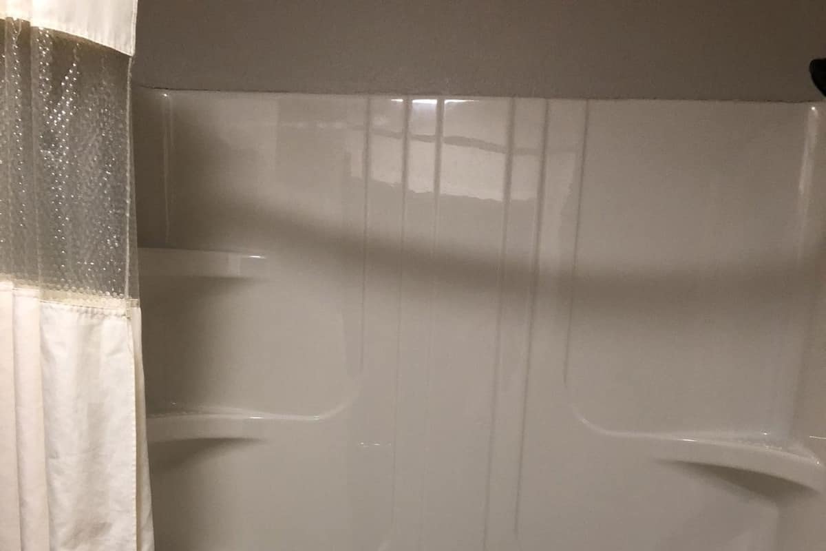Eine Badewanne mit Handtuch, Duschvorhang und Wasserhahn.