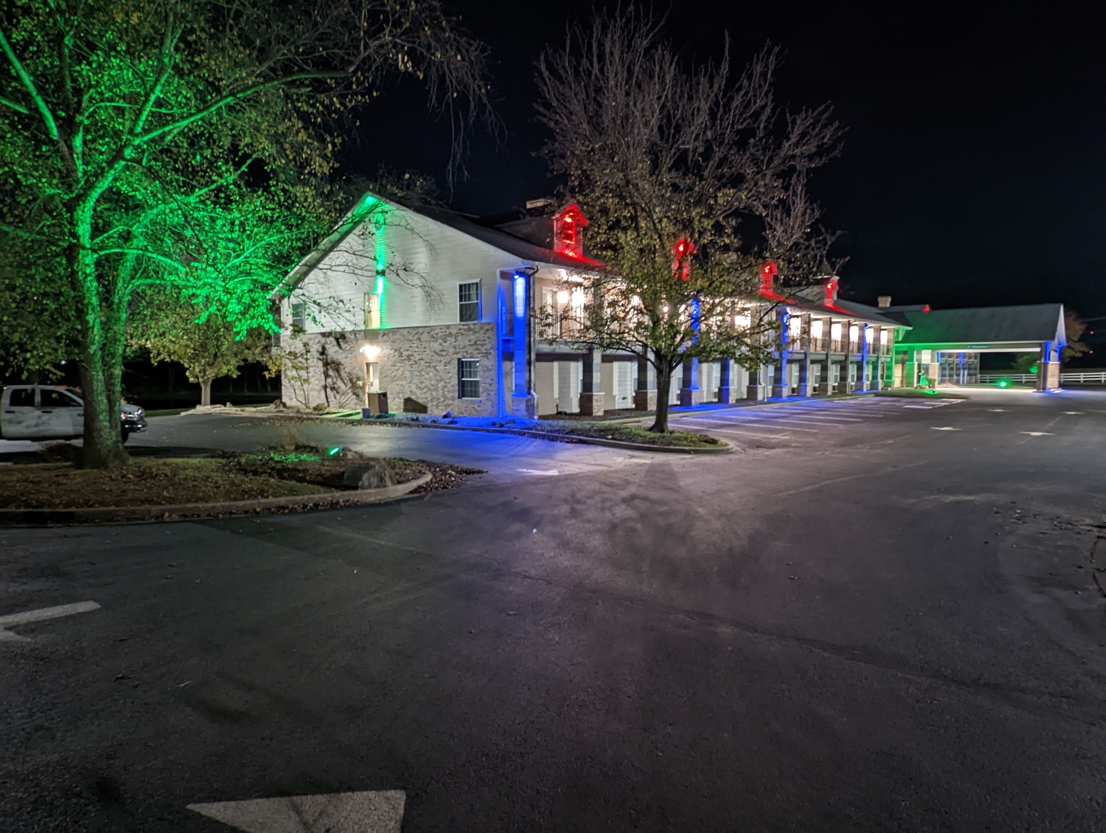 Un bâtiment à la façade en pierre, doté de nombreuses fenêtres et disposant d’un parking.