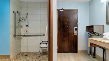 Une salle de bain avec douche, toilettes et lavabo.