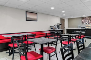 A restaurant interior with booths and tables, a counter, and a framed picture on the wall. - HomeTowne Studios by Red Roof Flint (Flint)
