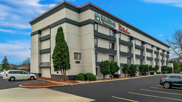 A hotel with a modern design, featuring a flat roof and a prominent sign for 'BisonTowne Studios'. - HomeTowne Studios by Red Roof Flint (Flint)