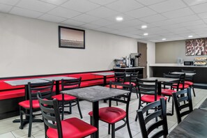 A restaurant interior with booths and tables, a counter, and a framed picture on the wall. - HomeTowne Studios by Red Roof Flint (Flint)