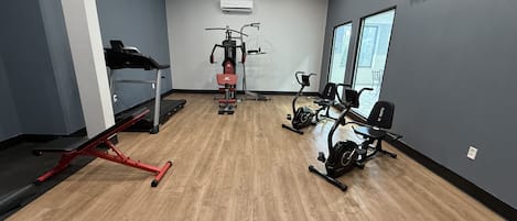 A gym with exercise equipment, a treadmill, and a stationary bike.