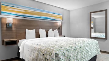 Ein Hotelzimmer mit einem großen Bett, einem Bettrahmen mit integrierter Beleuchtung, einem Wandbild und einem Spiegel.