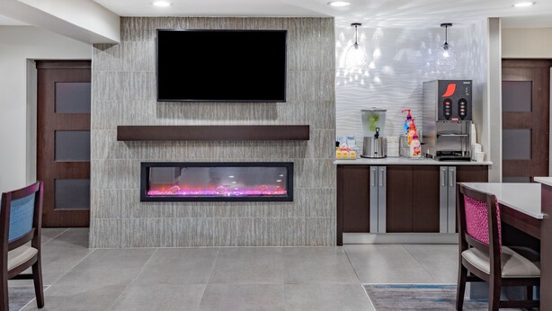 Una cocina moderna con un televisor de pantalla plana, chimenea empotrada y cafetera.