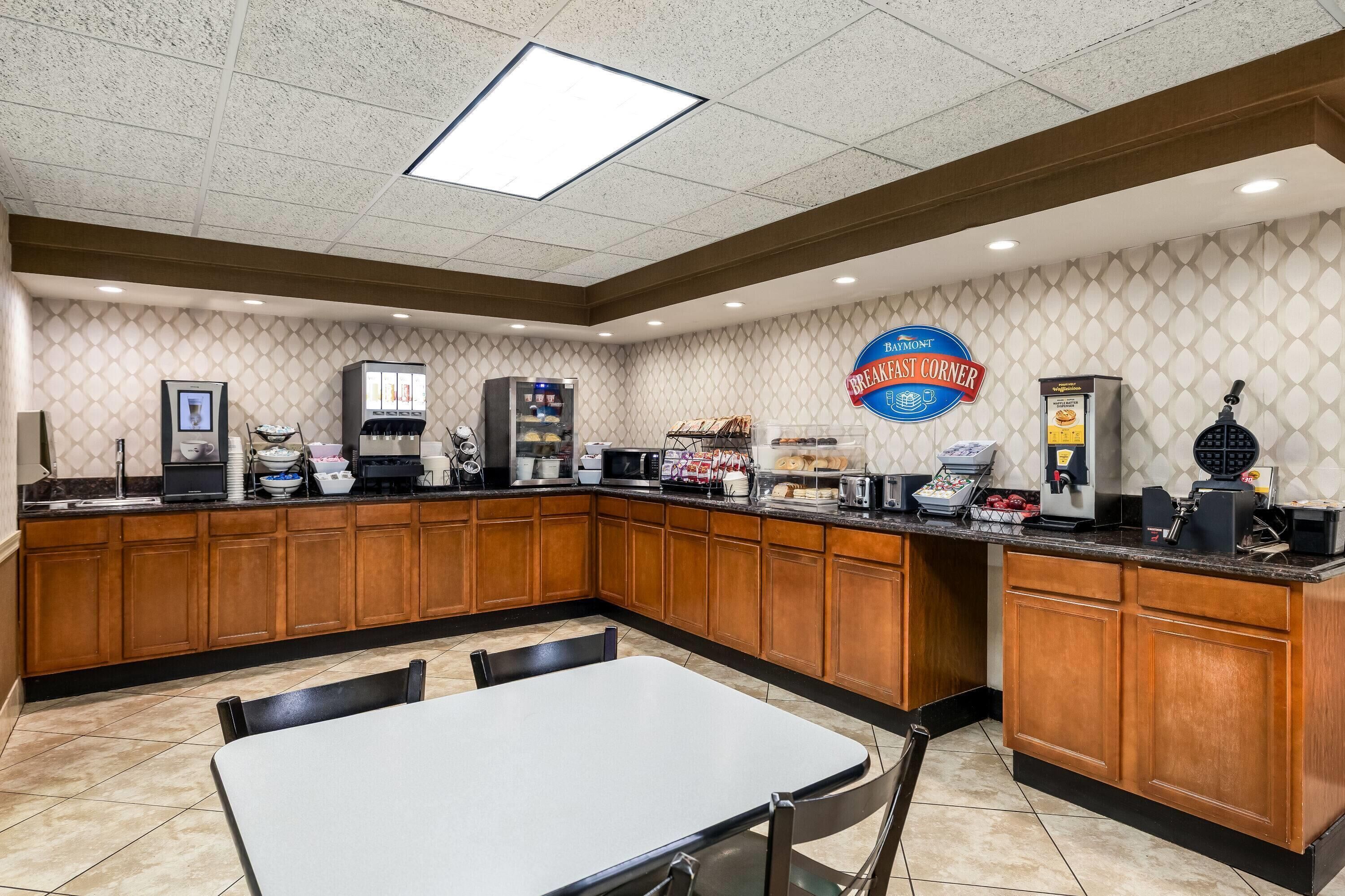 A breakfast area with a counter, seating, and a sign for 'Breakfast Corner.'