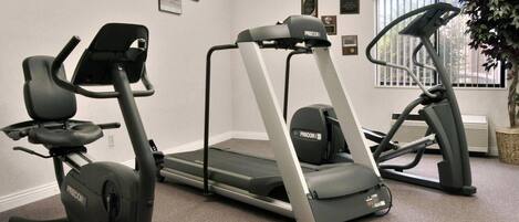 A fitness room with treadmills and elliptical machines.