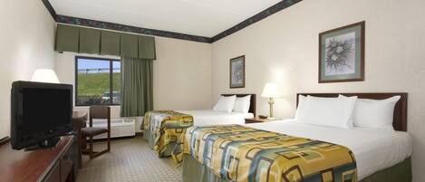Une chambre d’hôtel avec deux lits, une télévision, un bureau et une chaise.