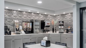 A modern kitchen with grey cabinets, a coffee machine, and a refrigerator. - Baymont by Wyndham La Crosse/Onalaska (Onalaska)