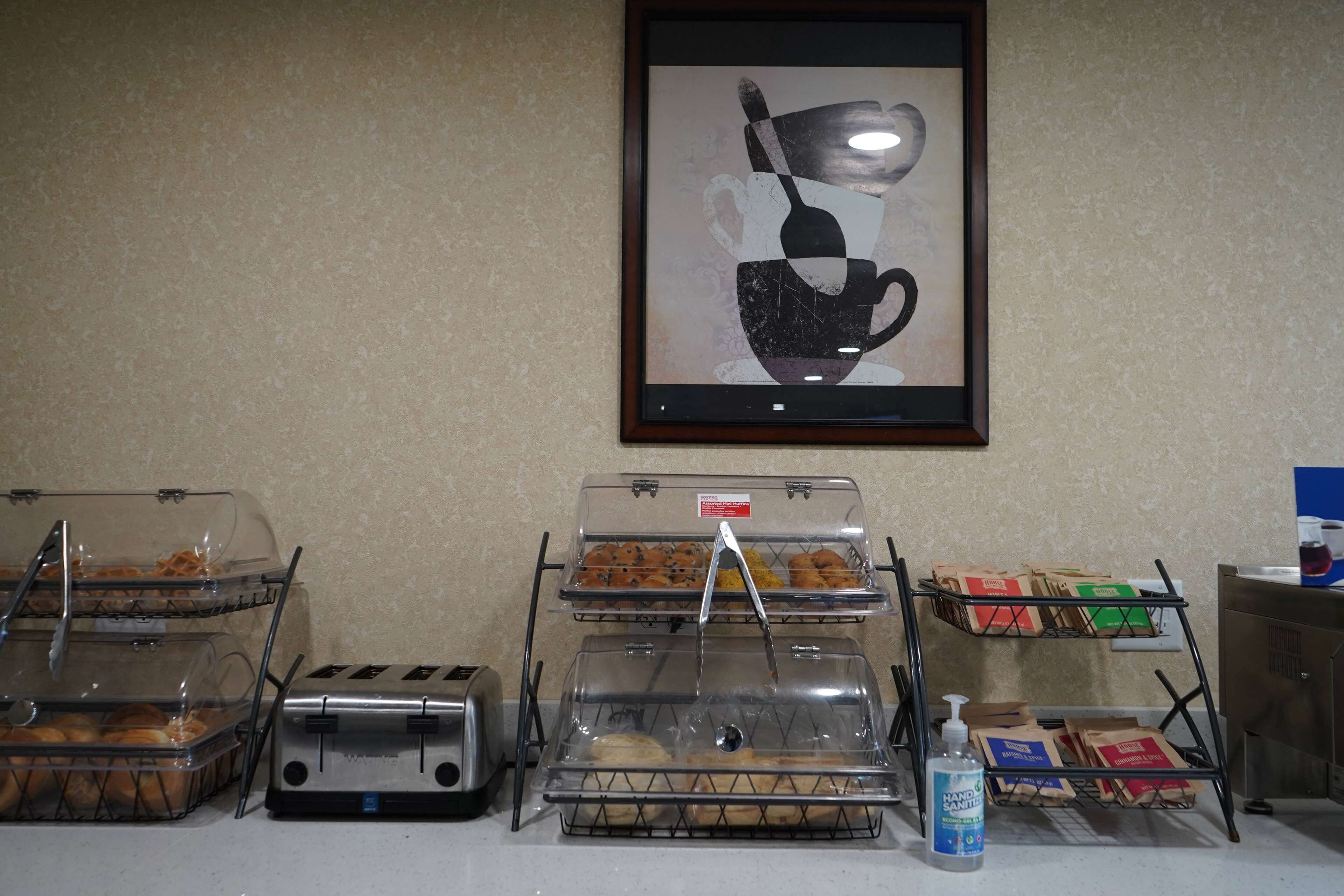 A breakfast buffet with various food items, including pastries and bread, displayed in clear containers.