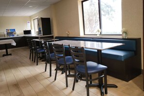 A restaurant with a long counter, blue cushioned booth, and several chairs. - Baymont by Wyndham Bridgeport/Frankenmuth (Bridgeport)