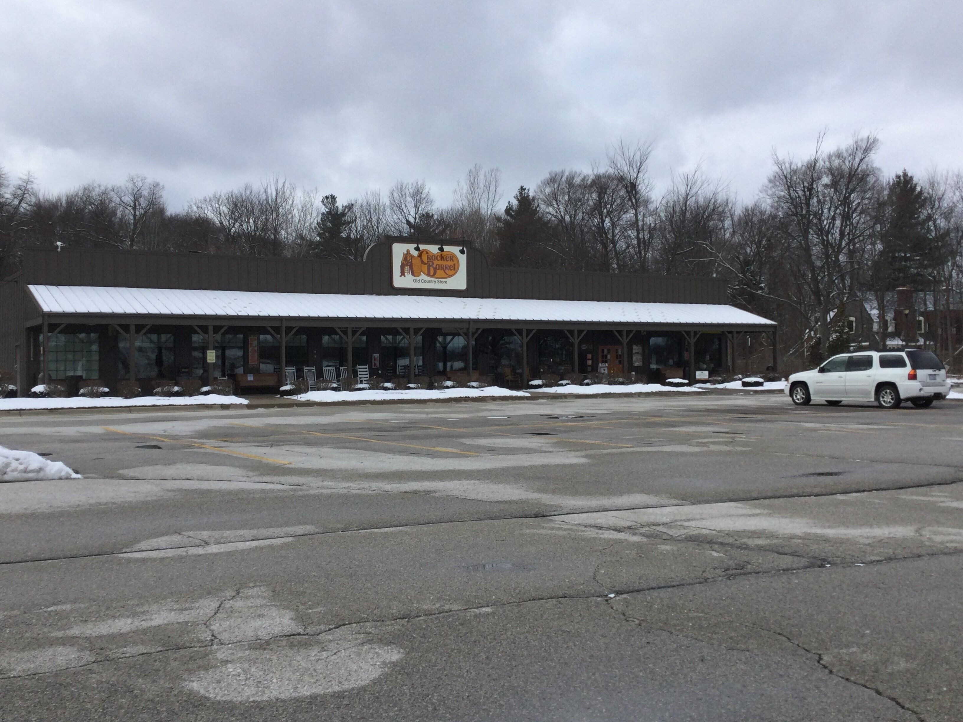 Un edificio con un grande cartello che riporta la scritta “Crocker Barrel Old Country Store” e un’area di parcheggio coperta.