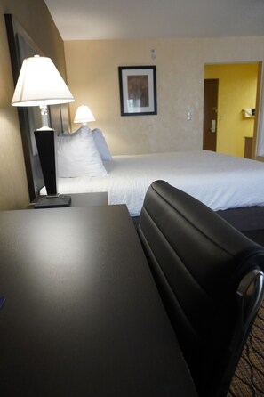 A hotel room with a bed, a desk, a chair, and two lamps. - Baymont by Wyndham Bridgeport/Frankenmuth (Bridgeport)