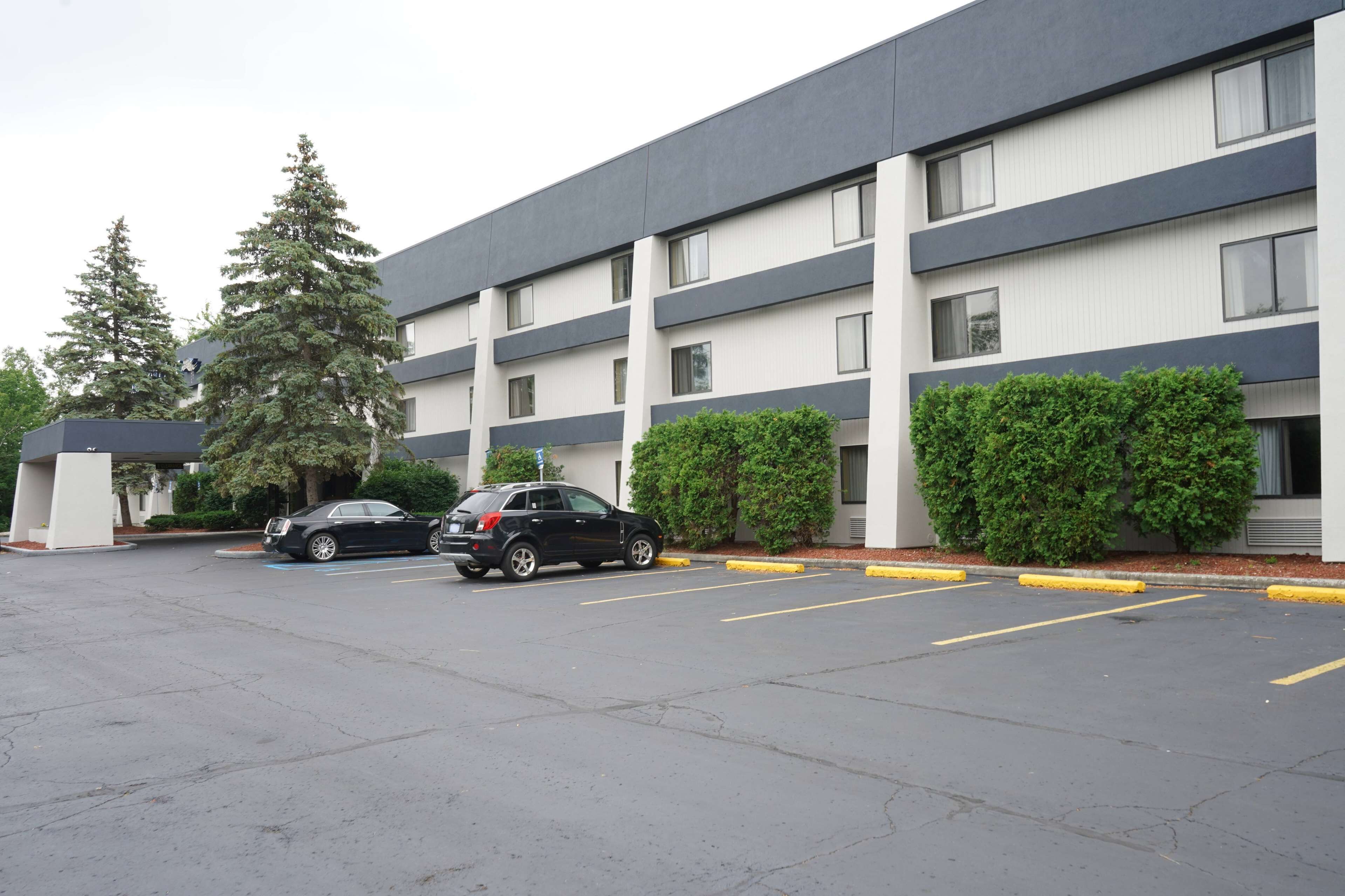 A multi-story parking garage with a black car parked in the foreground.