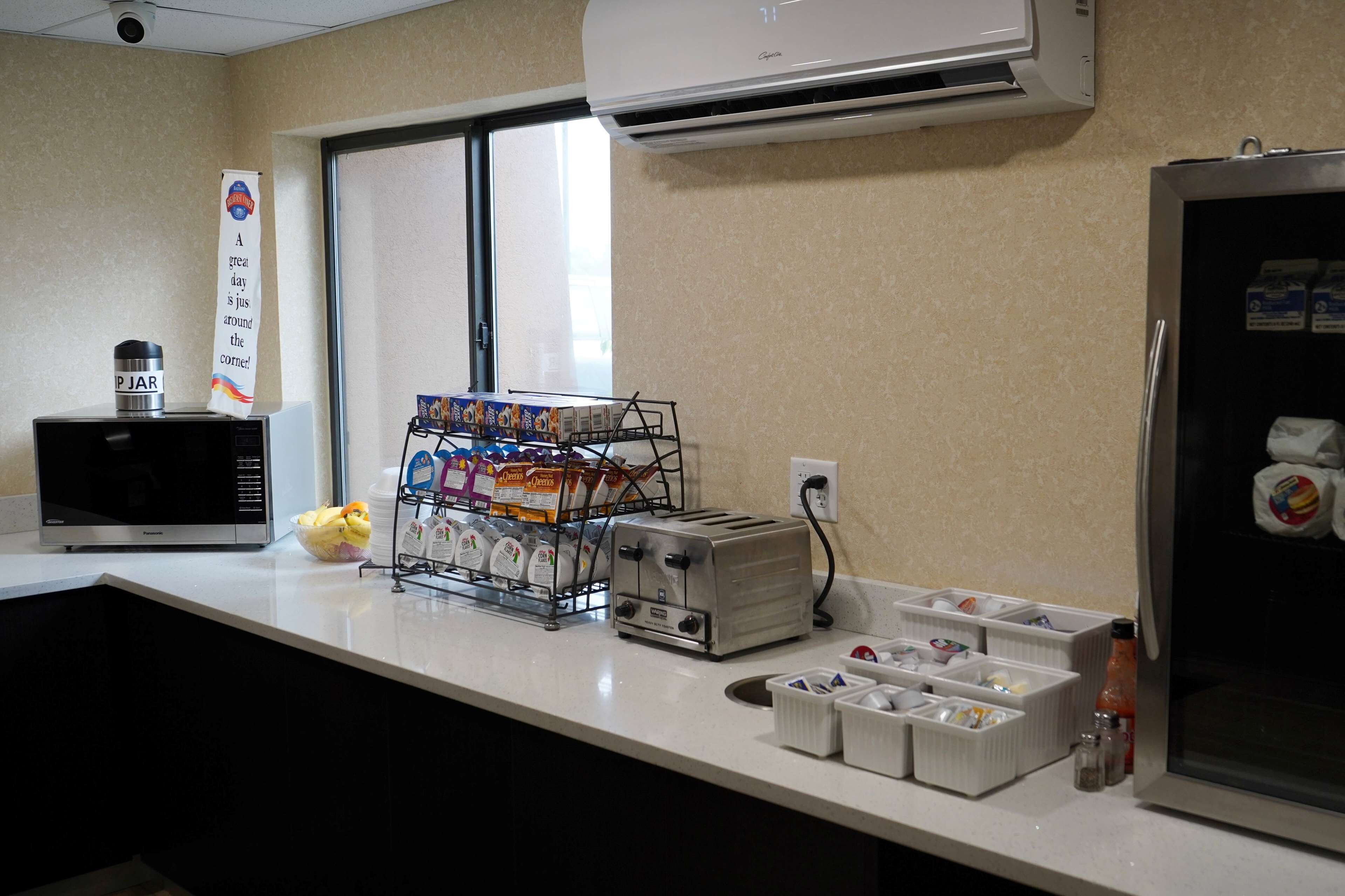 Una kitchenette equipada con microondas, tostadora y refrigerador.