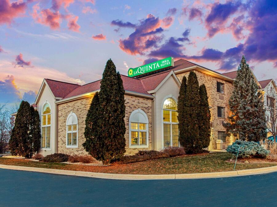 Un hotel con fachada de ladrillo, ventanas grandes y un letrero que dice "LaQuinta Inn & Suites".