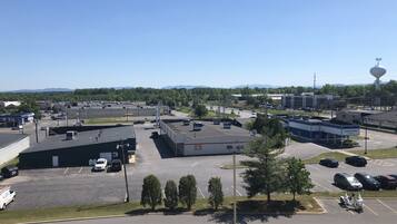 A parking lot with several cars and a few trucks, surrounded by buildings including a gas station and a bank.