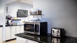 Uma cozinha moderna com micro-ondas, torradeira e máquina de café.