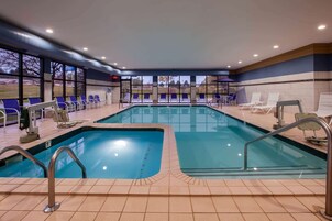 Una piscina con varias pistas, tumbonas y vistas al exterior.