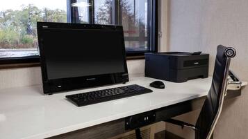 A desk with a Lenovo laptop, a Brother printer, a mouse, and a chair.
