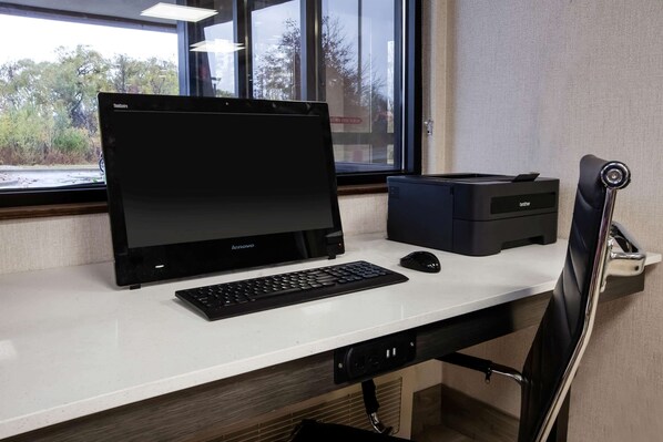 A desk with a Lenovo laptop, a Brother printer, a mouse, and a chair. - Baymont by Wyndham Traverse City (Traverse City)