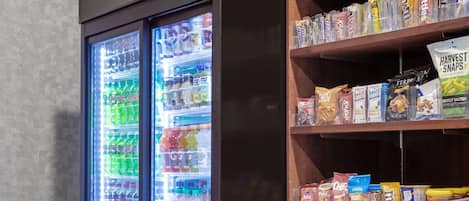 Una máquina expendedora con refrigerios y un dispensador de bebidas frías.