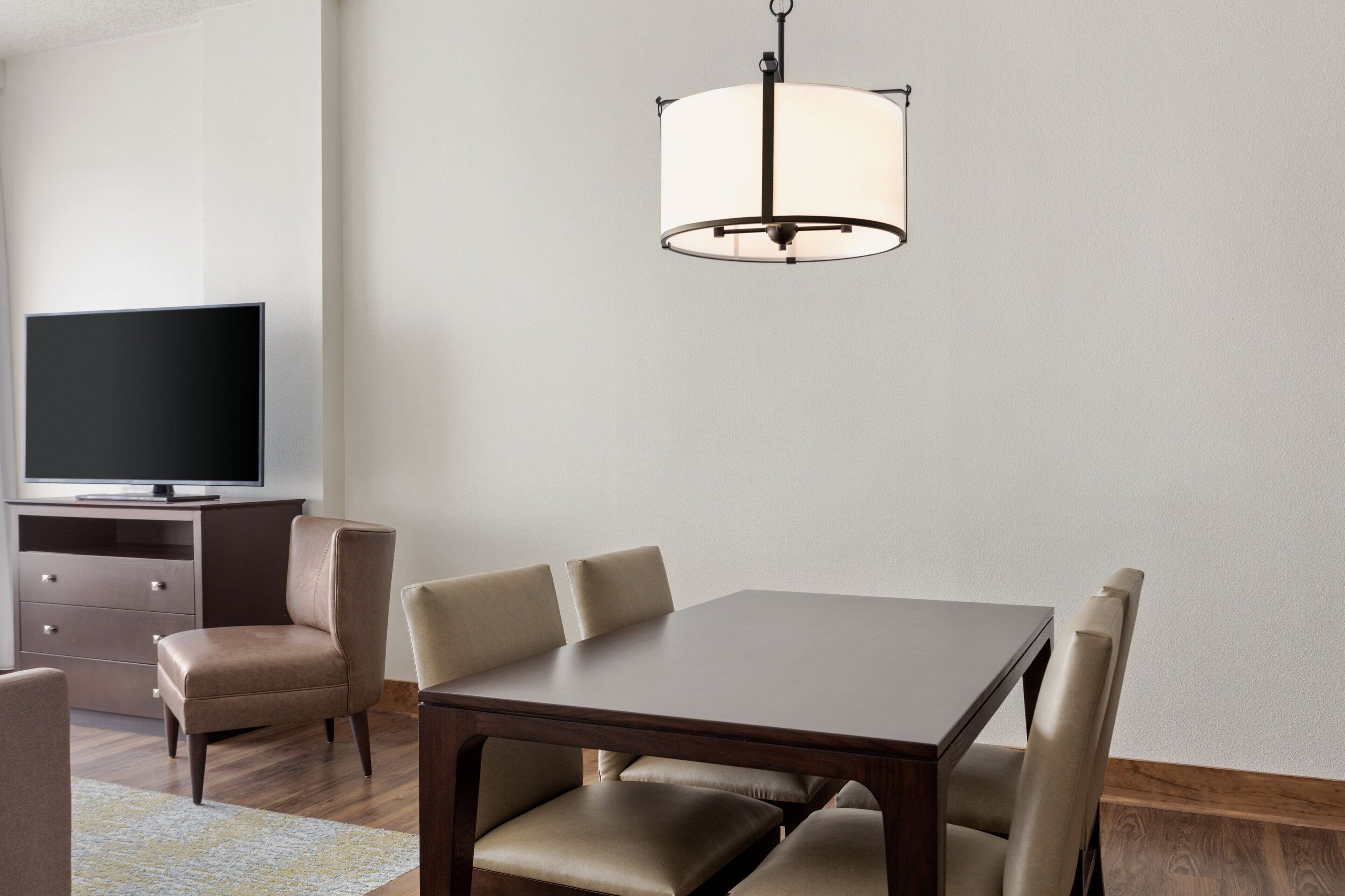 A dining area with a rectangular table, six chairs, and a hanging light fixture.