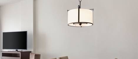 Un espace repas comprenant une table rectangulaire, six chaises et un luminaire suspendu.