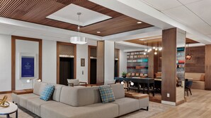A modern living room with a sectional sofa, dining area, and wooden accents. - Delta Hotels by Marriott Bristol (Bristol)
