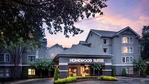 Un hôtel au design moderne, doté d’une entrée imposante et d’une enseigne indiquant « Homewood Suites ».