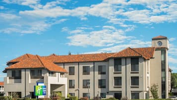 A hotel with a tiled roof, a clock tower, and a Holiday Inn Express sign.