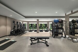 Un gimnasio con cintas de correr, una banca y pelotas de ejercicio.