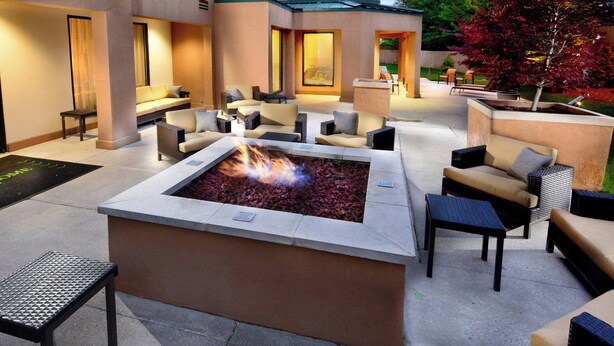An outdoor seating area with a fire pit, lounge chairs, and a small table. - Courtyard by Marriott Beckley (Beckley)